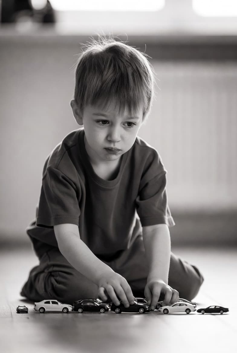 Child sitting alone while others play